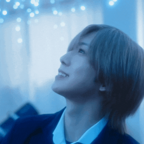 a close up of a person 's face with blue lights behind him