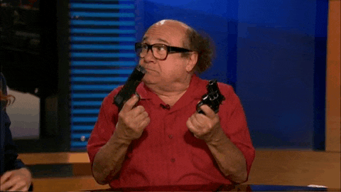 a man in a red shirt is holding two guns