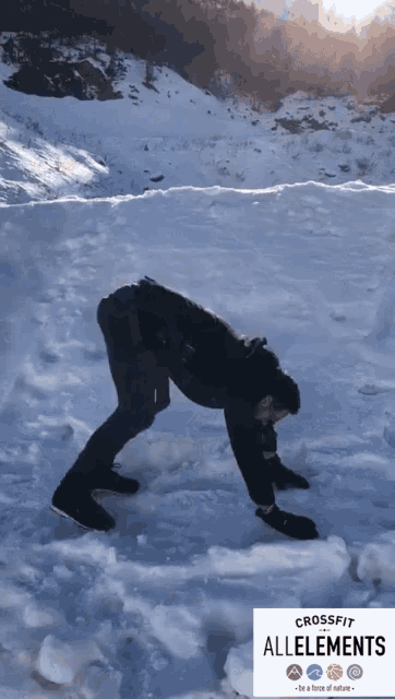 a man is bending over in the snow in front of a crossfit allements logo