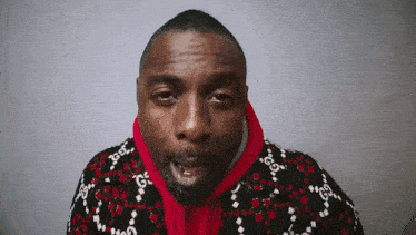 a man wearing a red and black sweater with gucci written on it