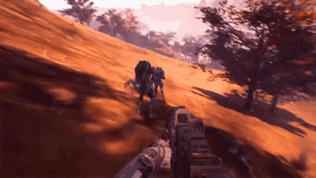 a person is holding a gun in a video game while a robot is walking down a hill .