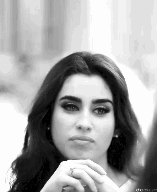 a black and white photo of a woman with her hand on her chin .