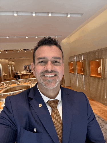 a man in a suit and tie is smiling in front of a jewelry store