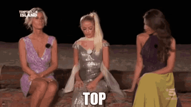 three women are sitting next to each other and one of them is wearing a dress that says top