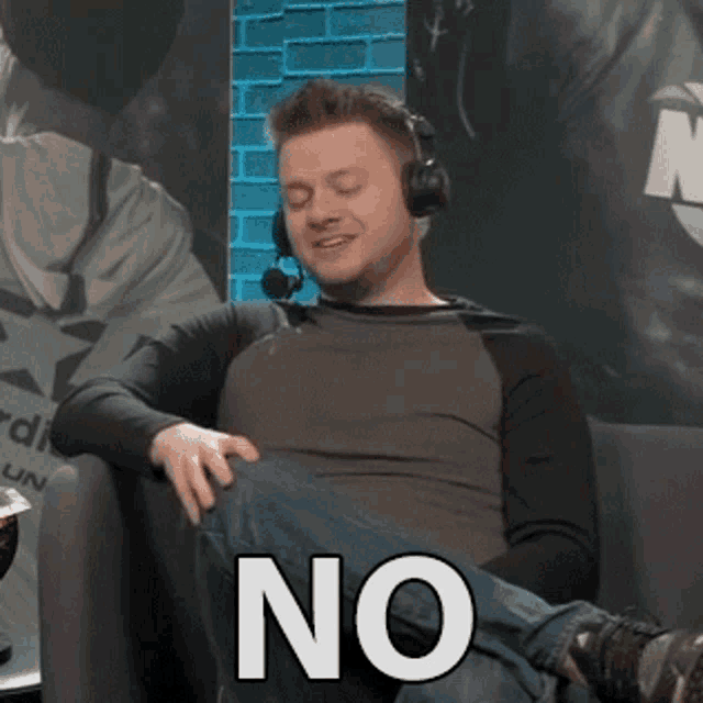 a man wearing headphones is sitting on a couch with his legs crossed and the word no written on his knee