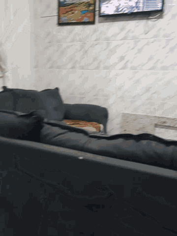 a living room with a couch and a tv on the wall