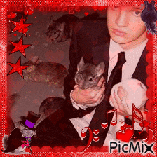a man in a suit and tie is holding a chinchilla in his arms