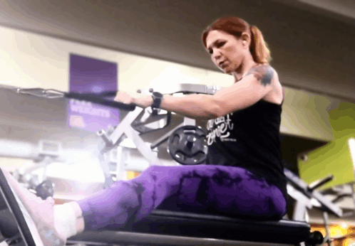 a woman is using a machine in a gym with a sign that says welcome