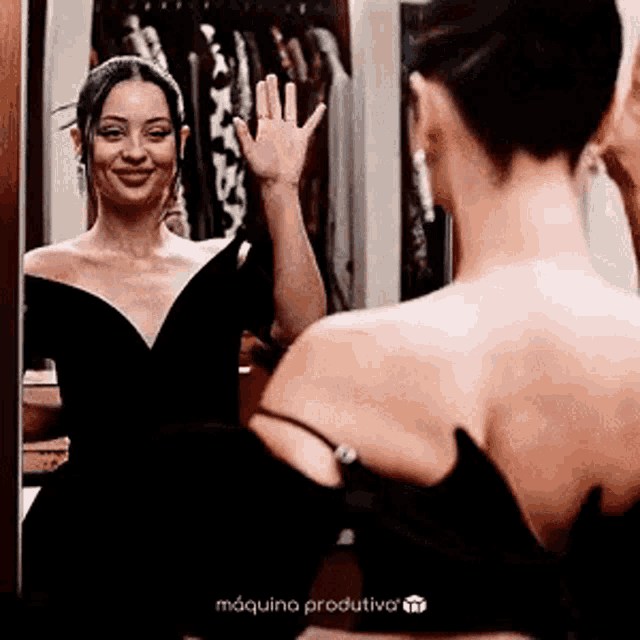 a woman is waving at her reflection in a mirror .