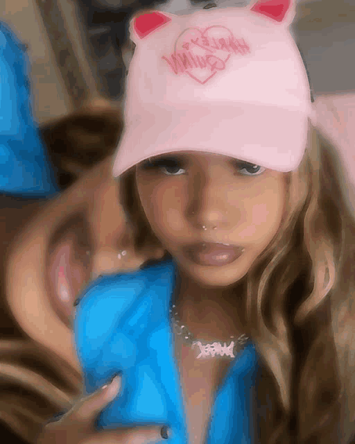 a woman wearing a pink hat with a heart on it and the word wing on it