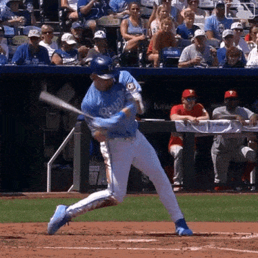 a baseball player wearing a blue jersey that says royals is swinging his bat