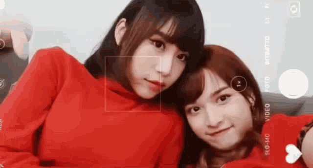 two girls are taking a selfie with a camera that says slo-mo on the bottom