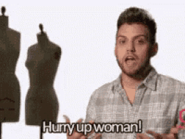 a man in a plaid shirt is standing in front of two mannequins and says hurry up woman .