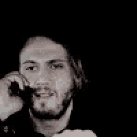 a man with a beard is talking on a cell phone in a dark room .