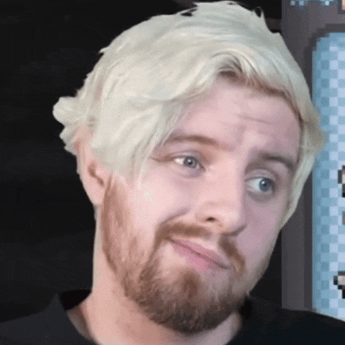 a man with a beard and blonde hair is making a funny face .