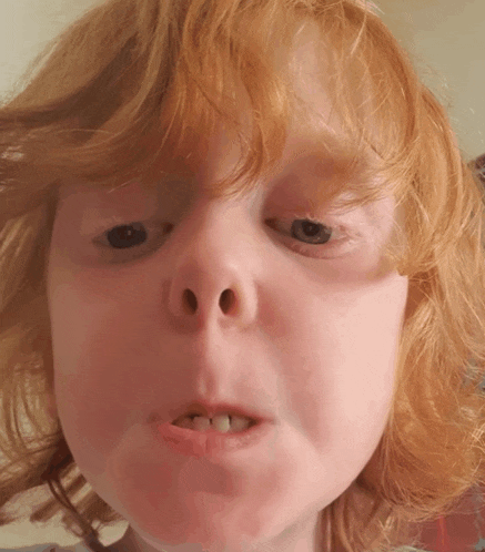 a little girl with red hair making a funny face