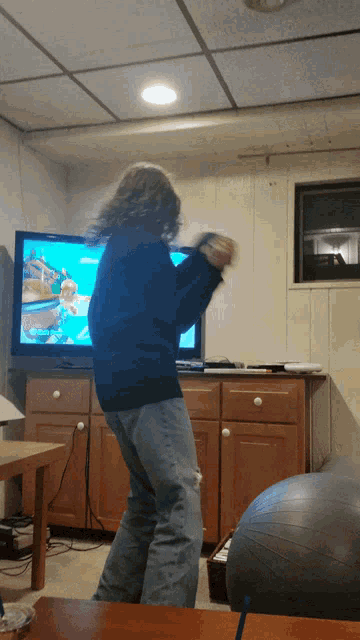 a person is playing a video game in front of a television