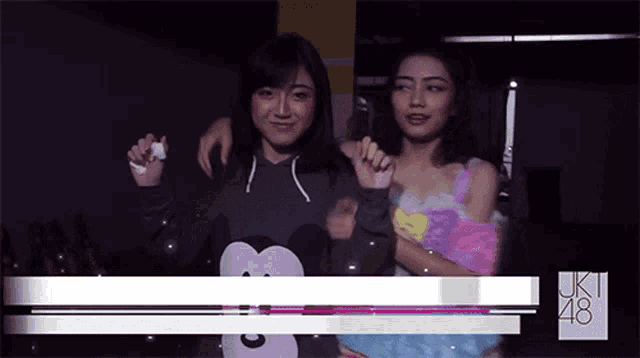 two girls standing next to each other with uk48 written on the bottom of the screen