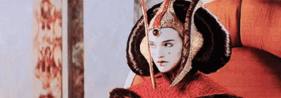 a woman in a costume is sitting on a couch wearing a helmet .
