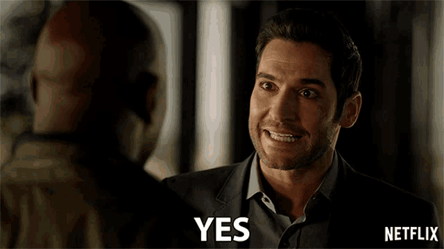 a man in a suit says yes in front of another man