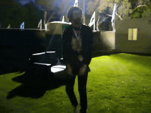 a man with a lanyard around his neck is walking in a field