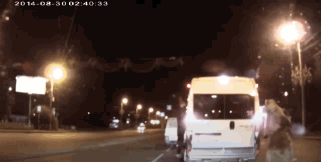 a white van is driving down a street at night with the date 2014-08-30