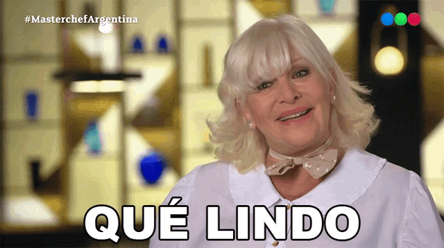 a woman in a white shirt is smiling with the words que lindo behind her
