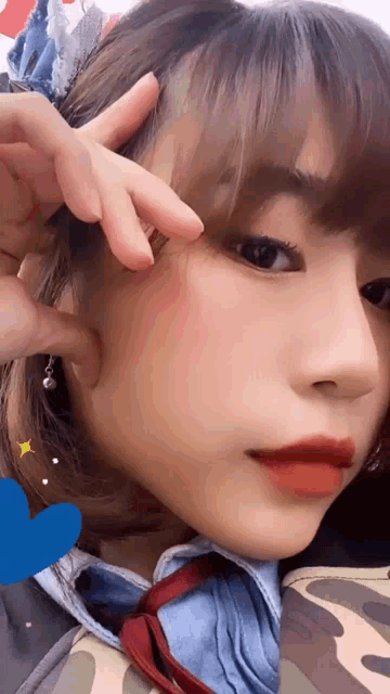 a close up of a girl 's face with a blue heart in the background