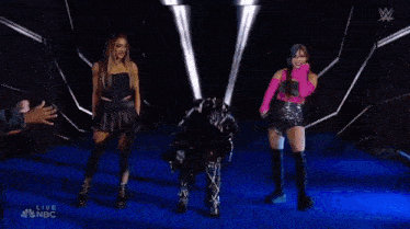 a group of women are standing next to each other on a stage and dancing .