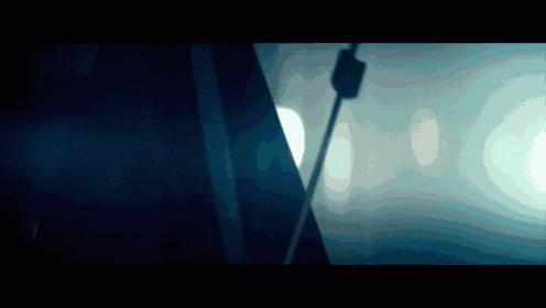 a dark room with a few lights shining through the window