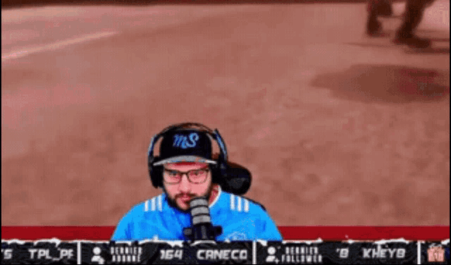 a man wearing headphones and a blue shirt with the word canecor on the bottom right