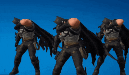 three men dressed as batman standing next to each other