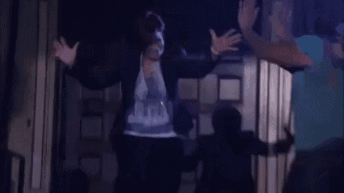 a group of people are dancing in front of a door .