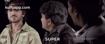 a group of men are standing next to each other and one of them is talking to another man .