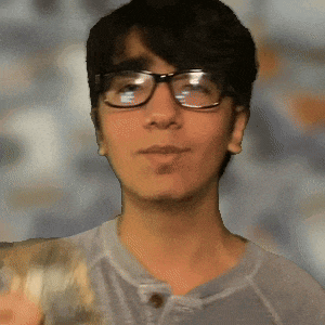 a young man wearing glasses and a gray shirt