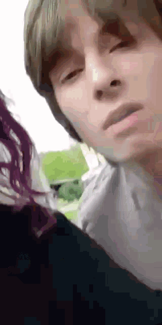 a close up of a man 's face with a woman 's hair behind him .