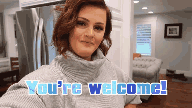a woman in a grey sweater says " you 're welcome " in blue letters