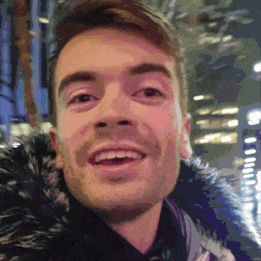 a close up of a man 's face with a fur collar