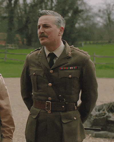 a man in a military uniform has a belt around his waist