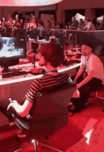a man is sitting in a chair playing a video game with a controller