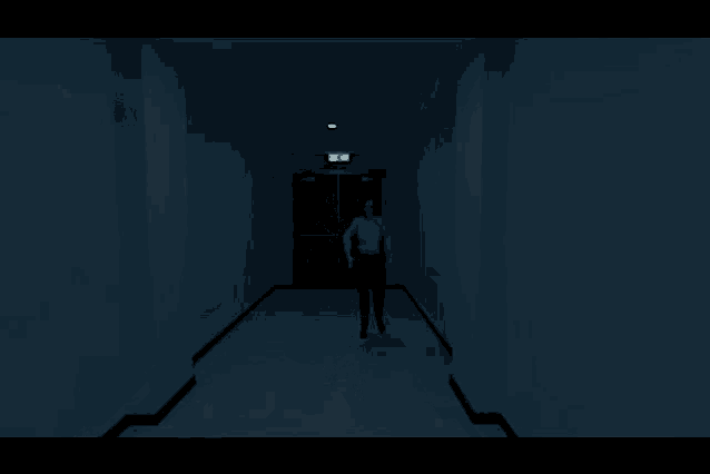 a dark hallway with a green exit sign