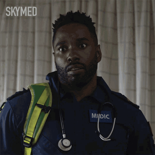 a man with a stethoscope around his neck has the word medic on his shirt