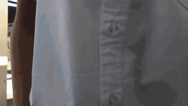 a close up of a person wearing a white shirt with buttons on the sleeves