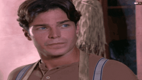 a man wearing suspenders and a button down shirt