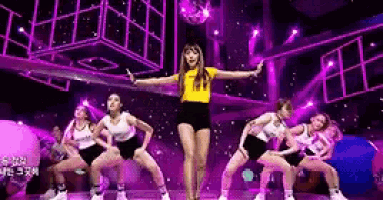 a group of women are dancing on a stage with a disco ball .