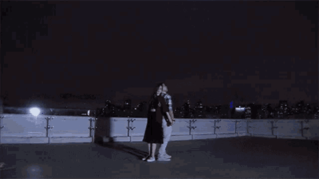 a couple dancing on a rooftop at night