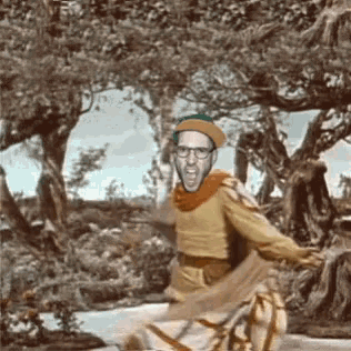 a man wearing glasses and a beret is dancing in a forest