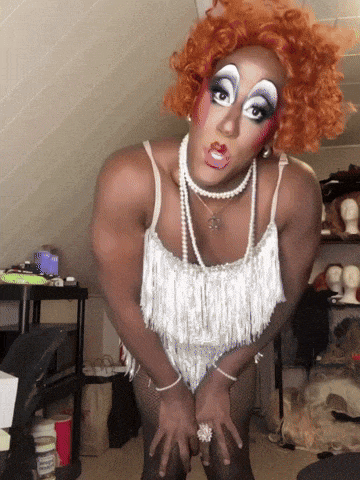 a drag queen wearing a white top and pearls