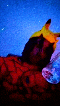 a person wearing a pikachu hat is sleeping with a bottle of water