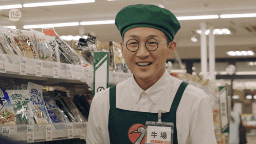 a man wearing glasses and a green hat has a name tag that says 牛場 on it